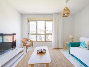 ein Wohnzimmer mit einem Sofa und einem Tisch in der Unterkunft Avatar Auditorio in Las Palmas de Gran Canaria