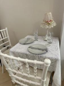una mesa blanca con un mantel blanco y un plato blanco en Изглед море студио Алекс Неа ПЕРАМОС, en Nea Peramos