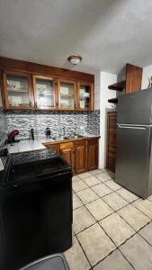 a kitchen with a stainless steel refrigerator and wooden cabinets at Manuel Antonio Inn CR in Manuel Antonio