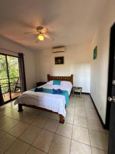 a bedroom with a bed and a ceiling fan at Manuel Antonio Inn CR in Manuel Antonio