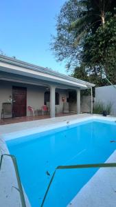 a swimming pool in front of a house at Manuel Antonio Inn CR in Manuel Antonio