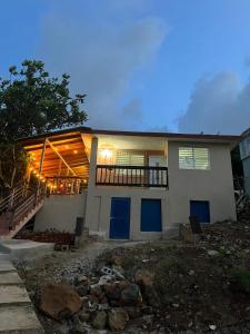 a house with blue doors and a balcony at Casa LOLO on hills of Culebra in Culebra