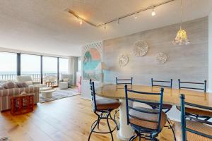 Una sala de estar con una mesa y sillas y un sofá. en Sea Colony --- 205N Edgewater, en Bethany Beach