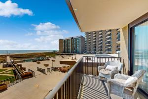 Un balcón con dos sillas y vista a la playa. en Sea Colony --- 205N Edgewater, en Bethany Beach