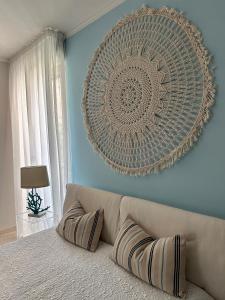 uma sala de estar com um sofá e uma grande arte de parede em mentamarina em Porto Recanati