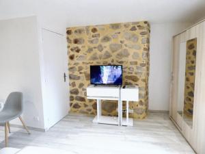 ブリウドにあるMaison de 3 chambres avec vue sur la ville et wifi a Brioudeの石壁の客室で、デスク(パソコン付)が備わります。