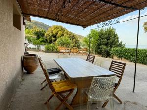 a wooden table and chairs on a patio at Maison à la campagne. in Sollacaro
