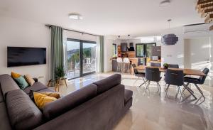 uma sala de estar com um sofá e uma sala de jantar em Villa Leona a luxury villa near Makarska, heated pool em Živogošće