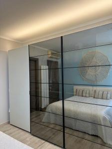 una camera con un letto con una parete in vetro di mentamarina a Porto Recanati