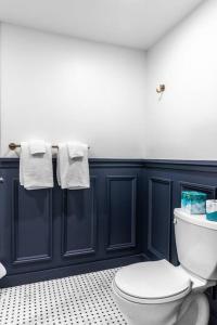 a bathroom with a white toilet and towels at King Bed, Fiber Internet, Heart of Bangor, 50 Roku TV, Room # 208 in Bangor +10 photos