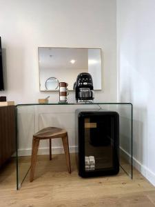 a glass table with a tv and a stool at King Bed, Fiber Internet, Heart of Bangor, 50 Roku TV, Room # 208 in Bangor