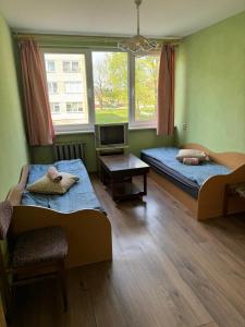 a room with two beds and a tv in it at Chernobyl type rooms in a block flat house in Šiauliai