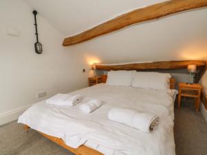 a bedroom with a large white bed with towels on it at Blencathra Barn in Penrith