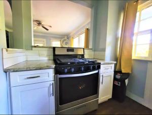 a kitchen with a stove and white cabinets at King bed and Queen Sofa bed / room TV Wifi in Decatur