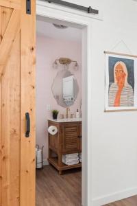 a room with a bathroom with a sink and a mirror at Southbound Stays - Little House in Nashville