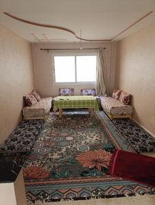 貝爾坎的住宿－appartement berkane，客厅配有桌子和地毯。