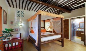 ein Schlafzimmer mit einem Himmelbett in einem Zimmer in der Unterkunft Diani Villa in Diani Beach