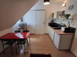 eine kleine Küche mit einem roten Tisch und einem roten Tisch in der Unterkunft Les studios d'Eric N6 in Tours