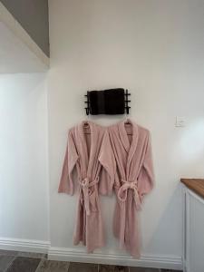 um robe cor-de-rosa está pendurado numa parede em Suite Bien être du Château de la Bouchatte em Chazemais