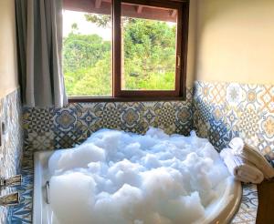 a room with a bath tub with clouds in it at Pousada Oliveri in Monte Verde