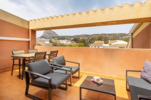 a balcony with chairs and tables and a view at Atico Milan in Jávea
