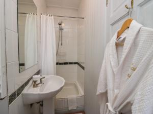 a white bathroom with a sink and a mirror at Lake Lodge Studio in Bowness-on-Windermere