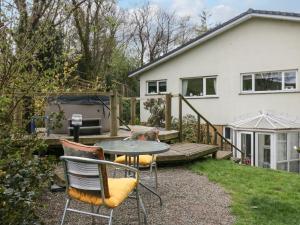 a patio with a table and chairs in front of a house at Lake Lodge Studio in Bowness-on-Windermere