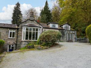 an old stone house with a large driveway at River Lodge in Ambleside