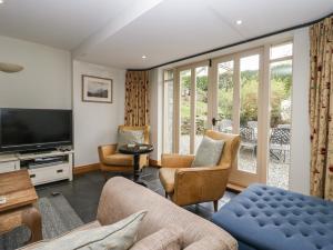 a living room with a couch and chairs and a television at River Lodge in Ambleside