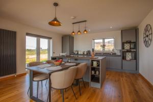 a kitchen with a table and chairs in a room at Driftwood in Pollachar