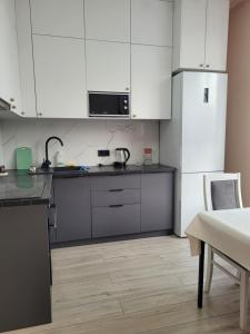 a kitchen with white cabinets and a counter top at ЖК Apple City 1 СПАЛЬНЯ in Prigorodnyy