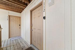 a hallway with a door and a wooden floor at Lei Lani Village 112 by Vacation Homes Collection in Orange Beach
