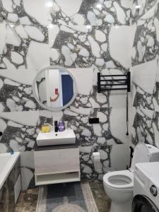 a bathroom with a sink and a mirror and a toilet at ЖК Apple City 1 СПАЛЬНЯ in Prigorodnyy