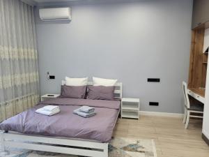 a bedroom with a bed with two towels on it at ЖК Apple City 1 СПАЛЬНЯ in Prigorodnyy