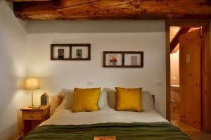 1 dormitorio con 1 cama con 2 almohadas amarillas en Rifugio Lou Lindal en Canosio