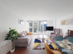 a living room with a couch and a table at Deluxe Two Bed Apartment by London ExCeL & O2 in London