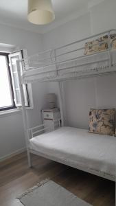 a white bunk bed in a room with a window at Cantinho do Céu in Alcácer do Sal