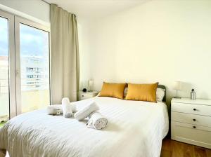 - une chambre avec un grand lit blanc et des serviettes dans l'établissement Tres Bel Appartement 6P Terasse - Levallois, à Levallois-Perret