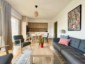 - un salon avec un canapé bleu et une table dans l'établissement Tres Bel Appartement 6P Terasse - Levallois, à Levallois-Perret