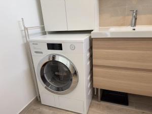 - un lave-linge et un sèche-linge dans une cuisine à côté d'un évier dans l'établissement Tres Bel Appartement 6P Terasse - Levallois, à Levallois-Perret