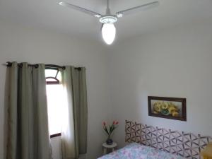 sypialnia z wentylatorem sufitowym i łóżkiem w obiekcie Bragança's Houses w mieście Cabo Frio