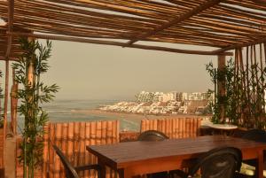 een tafel met stoelen en uitzicht op de oceaan bij Casa mar surfhouse in Punta Hermosa