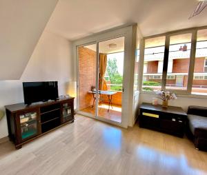 Sun pool duplex apartment by HLCLUB Agency في فيلانوفا إ لا غيلترو: غرفة معيشة مع تلفزيون بشاشة مسطحة وأريكة