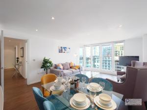 a living room with a table and chairs at Deluxe Two Bed Apartment by London ExCeL & O2 in London