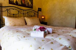 una camera da letto con un letto bianco e fiori di Wunderschöne Ferienwohnung in Monte San Savino mit gemeinschaftlichem Pool, Garten und Grill a Monte San Savino
