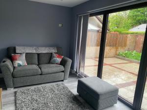 ein Wohnzimmer mit einem Sofa und einer Glastür in der Unterkunft Ty Haf in Aberdare