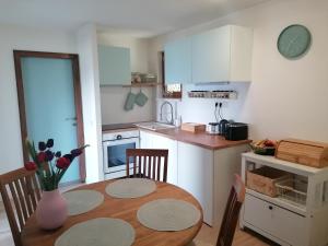 a kitchen with a wooden table and a dining room at Landhaus beim Pyramidenkogel in Linden