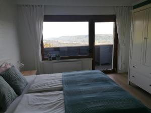 a bedroom with a bed with a large window at Landhaus beim Pyramidenkogel in Linden
