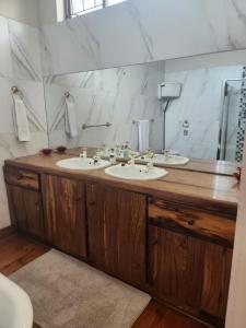un bagno con due lavandini e un grande specchio di Unique Guest House a Hallack Rock