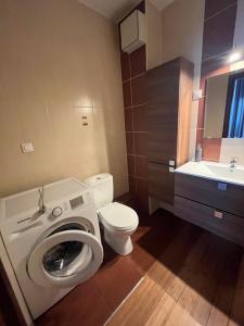 a bathroom with a washing machine and a toilet at Apartament Borkowo in Borkowo